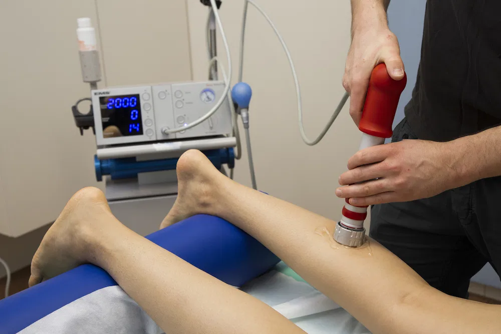 Stosswellentherapie am Unterschenkel mit dem Therapiegerät